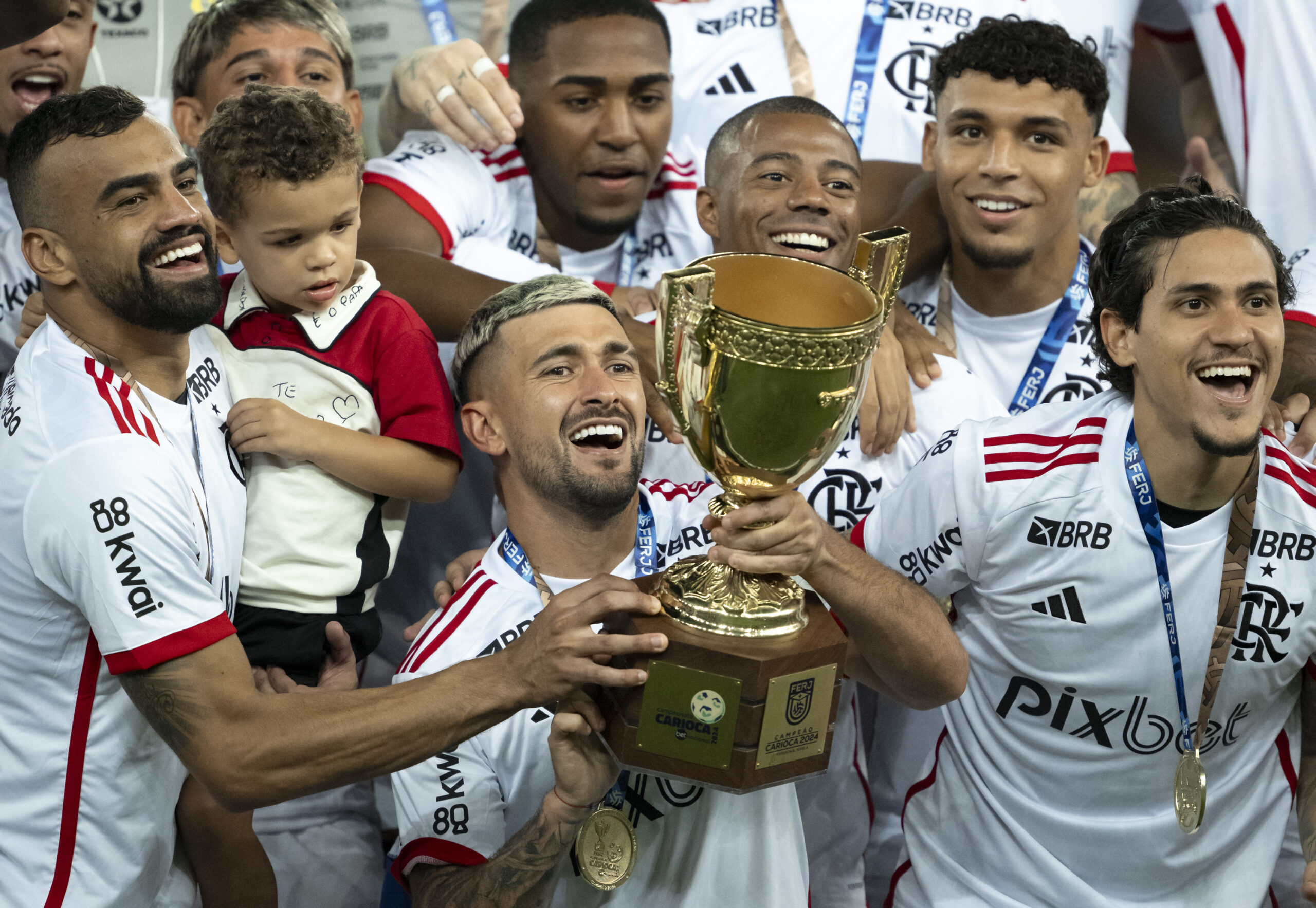 Fotografia real de campo do elenco rubro-negro vestindo o Manto Sagrado de 2024 nas conquistas do Campeonato Carioca Invicto e do Pentacampeonato da Copa do Brasil. (Fonte Oficial: Diário Lance! / Agência AGIF & O Globo (2024))