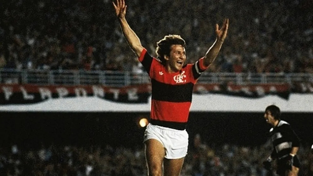 Fotografia real de Zico em campo vestindo o Manto Sagrado Adidas de 1981 na campanha histórica da Taça Libertadores da América e do Mundial Interclubes (45 gols na temporada, 11 na Libertadores e eleito o melhor em campo nos 3x0 sobre o Liverpool em Tóquio). (Acervo Jornal dos Sports (Edições Originais de Nov/Dez de 1981), O Globo, Jornal do Brasil, Revista Placar & Diário Lance!)