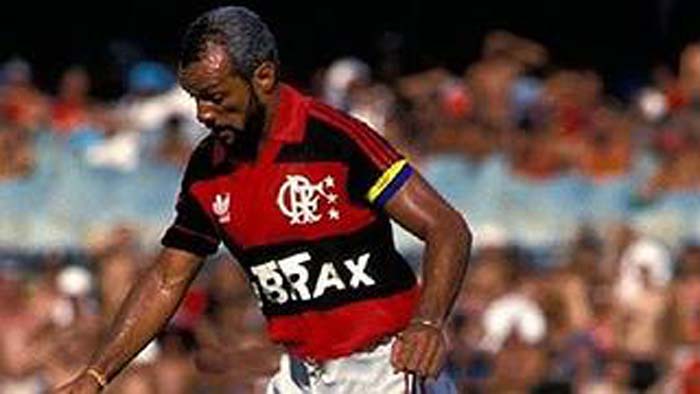 Fotografia real do lateral e maestro Leovegildo Lins da Gama Júnior, recordista absoluto de jogos da história do Flamengo (876 partidas), em ação nos anos 1980. Ao lado de Zico, Leandro, Andrade e Adílio, Júnior comandou o Bicampeonato Brasileiro de 1982 no Olímpico e o Tricampeonato Brasileiro de 1983 diante de 155.523 pagantes no Maracanã. (Fonte Oficial: Diário Lance! & Acervo O Globo · Arquivo Fotográfico Lance! / Agência O Globo)