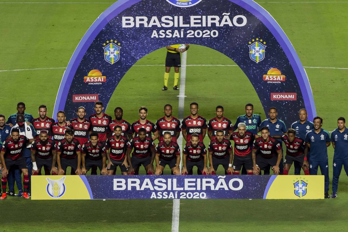 Fotografia real de Adriano Vizoni / Folhapress publicada pela Folha de S.Paulo registrando Diego Ribas, Everton Ribeiro, Gabigol, Filipe Luís, Bruno Henrique, Gerson e Rogério Ceni erguendo a taça do Octacampeonato Brasileiro no Morumbi. Na aba '📰 Recorte de Jornal', confira o Pôster Oficial de Campeão publicado pelo jornal Folha de S.Paulo. (Fonte Oficial: Folha de S.Paulo / Folhapress & Diário Lance! · Adriano Vizoni / Folhapress & Alexandre Vidal (CRF / Lance!))